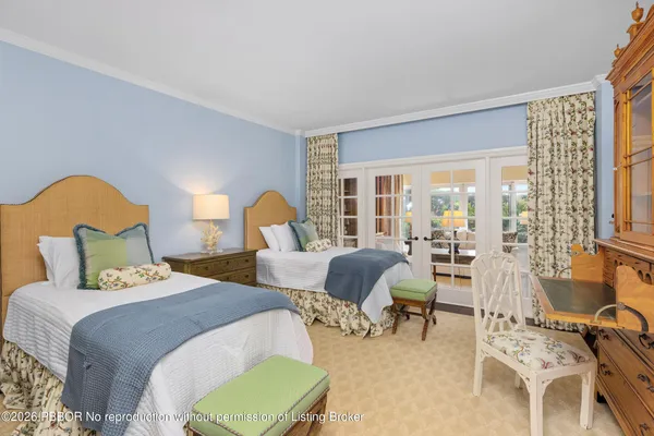 a spacious bedroom with two beds and a large window