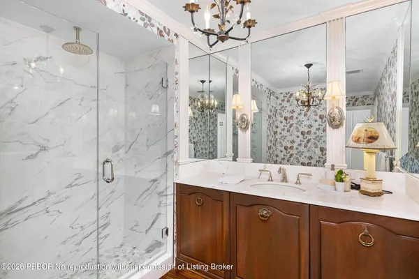 a bathroom with a double vanity sink mirror and shower