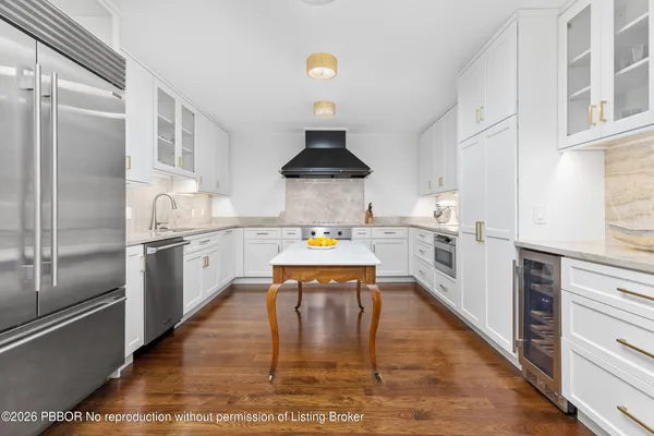 a kitchen with stainless steel appliances granite countertop a stove refrigerator and a sink