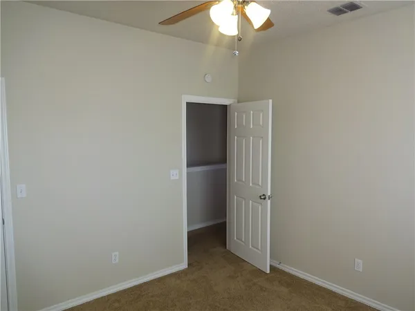 an empty room with a chandelier fan