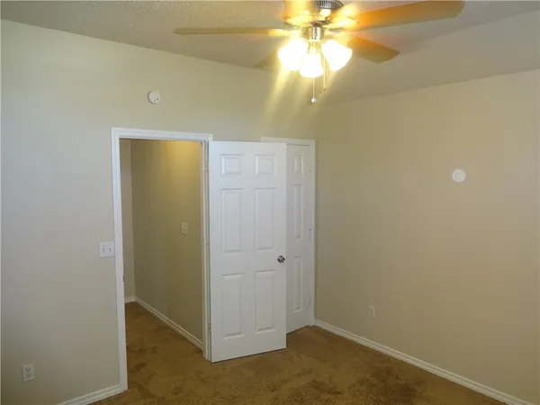 an empty room with a chandelier fan and a chandelier fan