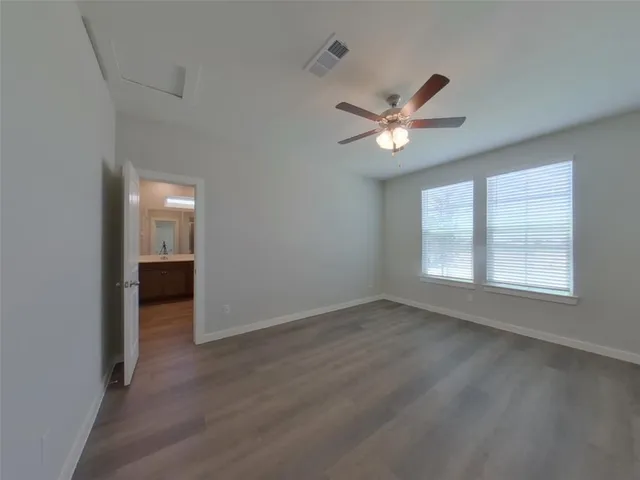 an empty room with closet and a ceiling fan
