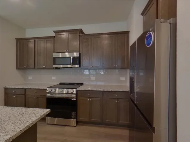 a kitchen with stainless steel appliances granite countertop a sink and a stove