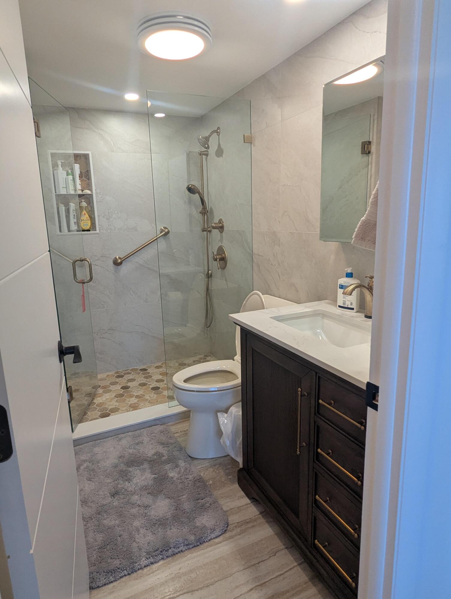 2121 North Ocean Boulevard, Unit 1006E Boca Raton, FL 33431 - Photo 38 of 64 a bathroom with a sink toilet a shower and a mirror