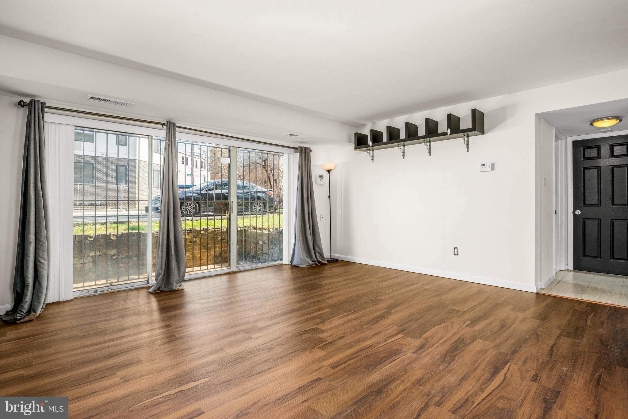1920 Naylor Road Southeast, Unit T2 Washington, DC 20020 - Photo 4 of 25 a view of an empty room with wooden floor and a window