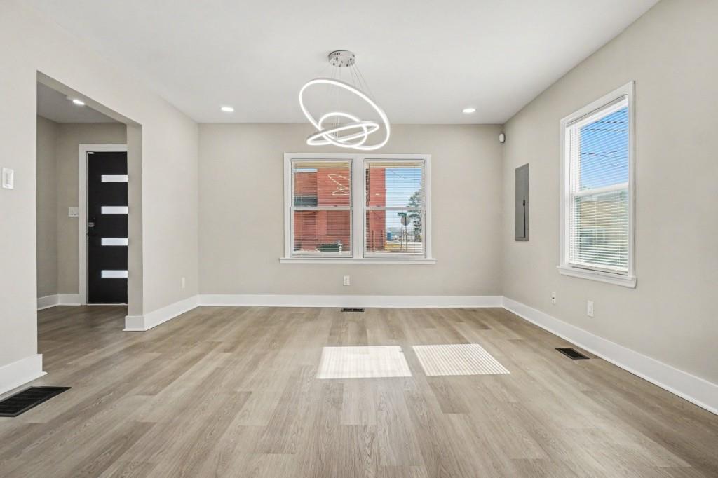 1515 Jonesboro Road Southeast Atlanta, GA 30315 - Photo 12 of 32 an empty room with wooden floor cabinet and windows