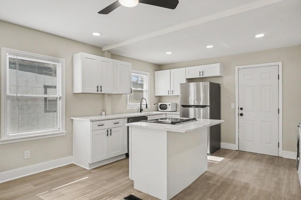 1515 Jonesboro Road Southeast Atlanta, GA 30315 - Photo 18 of 32 a kitchen with stainless steel appliances granite countertop a refrigerator a sink dishwasher a stove and white countertops with wooden floor