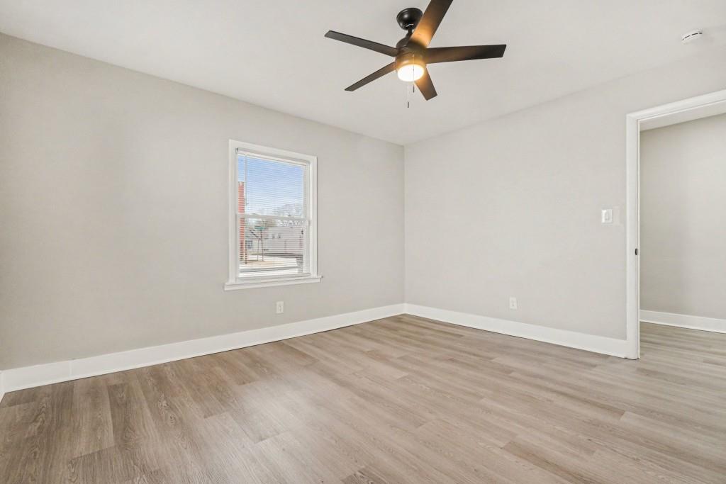 1515 Jonesboro Road Southeast Atlanta, GA 30315 - Photo 22 of 32 an empty room with wooden floor ceiling fan and windows