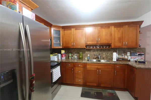 a kitchen with stainless steel appliances granite countertop a refrigerator and a sink