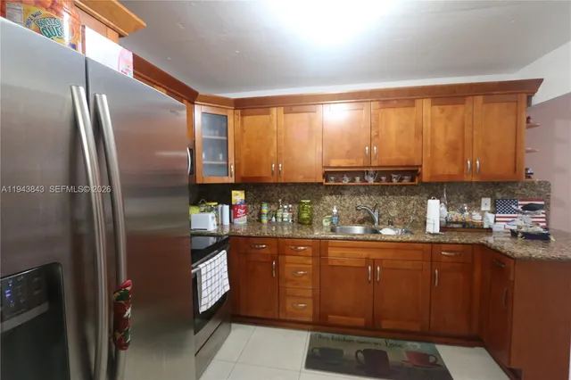 a kitchen with stainless steel appliances granite countertop a refrigerator and a sink