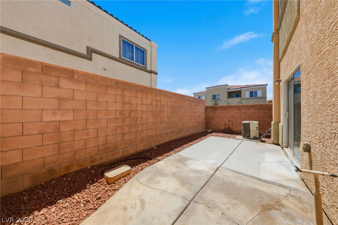 6312 Sandy Ridge Street, Unit 3102 North Las Vegas, NV 89081 - Photo 30 of 31 A compact patio space offers low-maintenance outdoor living with a sturdy block fence and easy-care gravel landscaping.