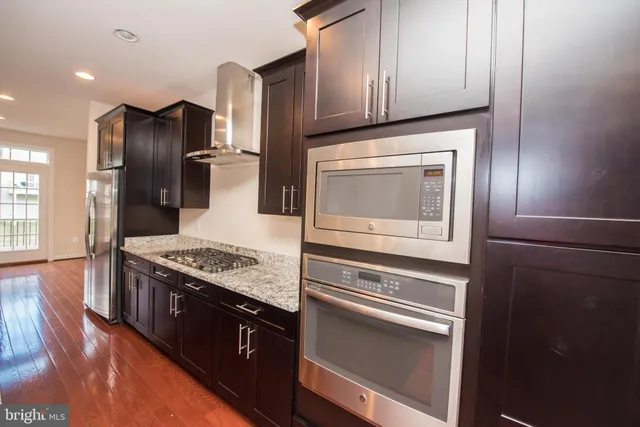 a kitchen with granite countertop stainless steel appliances and wooden cabinets