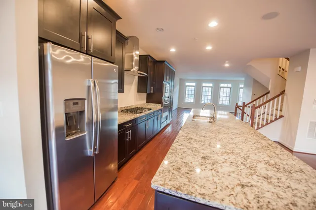 a kitchen with stainless steel appliances granite countertop a refrigerator and a sink