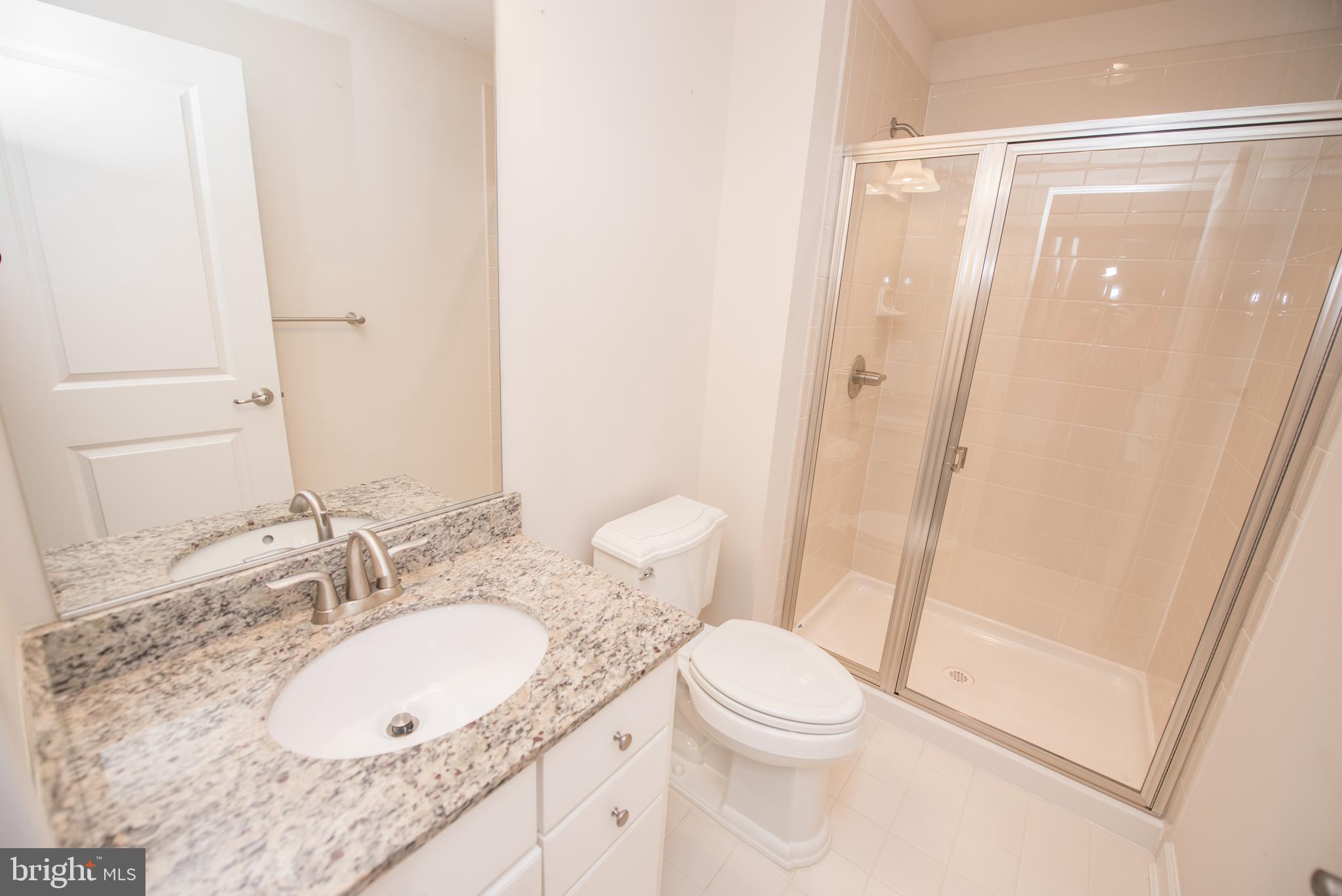 7444 Burnside Way Hanover, MD 21076 - Photo 30 of 46 a bathroom with a granite countertop sink toilet and shower