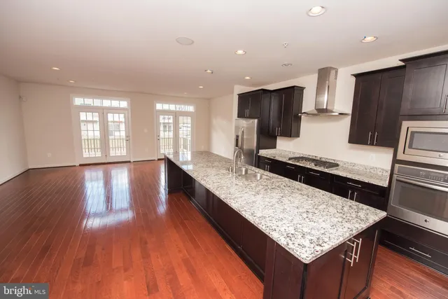 a kitchen with large counter space and wooden floor