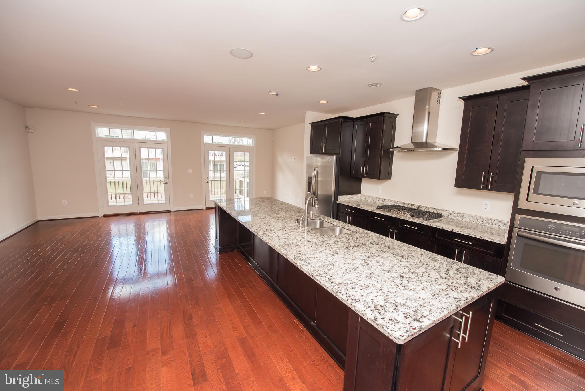 7444 Burnside Way Hanover, MD 21076 - Photo 4 of 46 a kitchen with large counter space and wooden floor