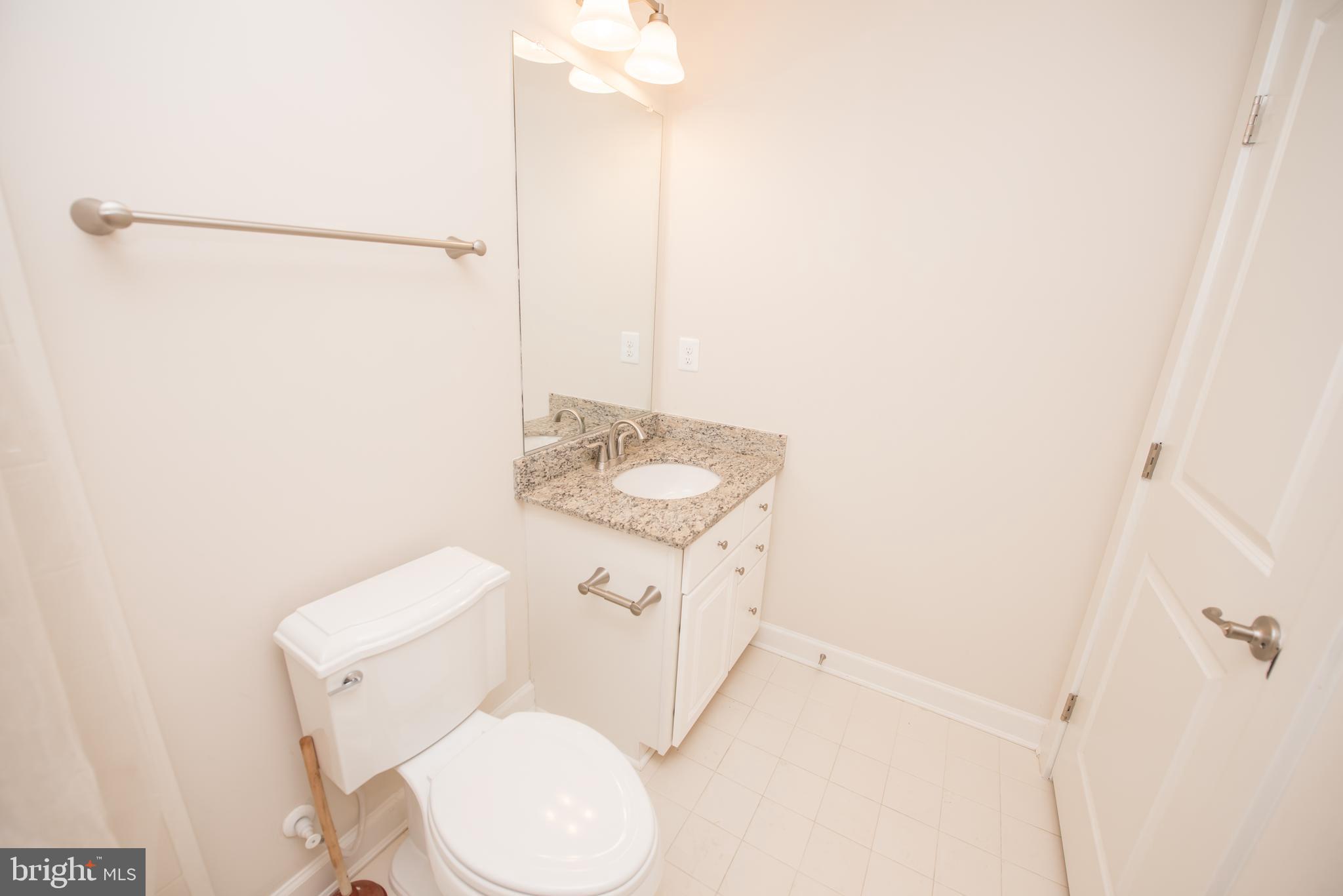 7444 Burnside Way Hanover, MD 21076 - Photo 45 of 46 a bathroom with a toilet sink and shower curtain