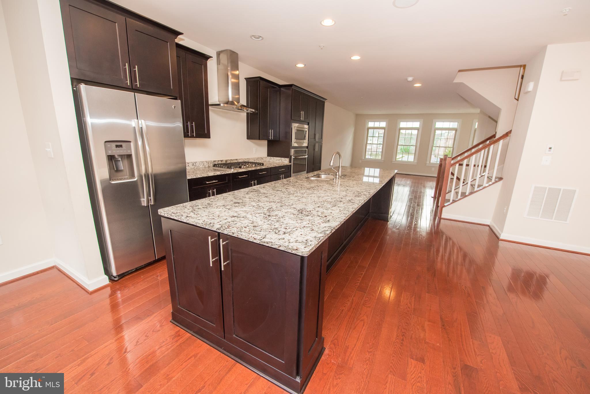 7444 Burnside Way Hanover, MD 21076 - Photo 8 of 46 a kitchen with stainless steel appliances granite countertop a refrigerator a stove and a wooden floors