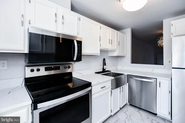 a kitchen with stainless steel appliances a stove a sink dishwasher and cabinets