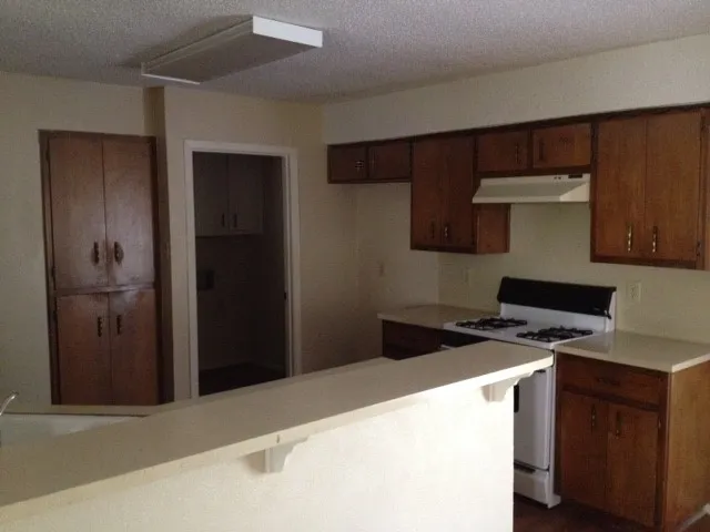 a kitchen with a refrigerator and a stove top oven