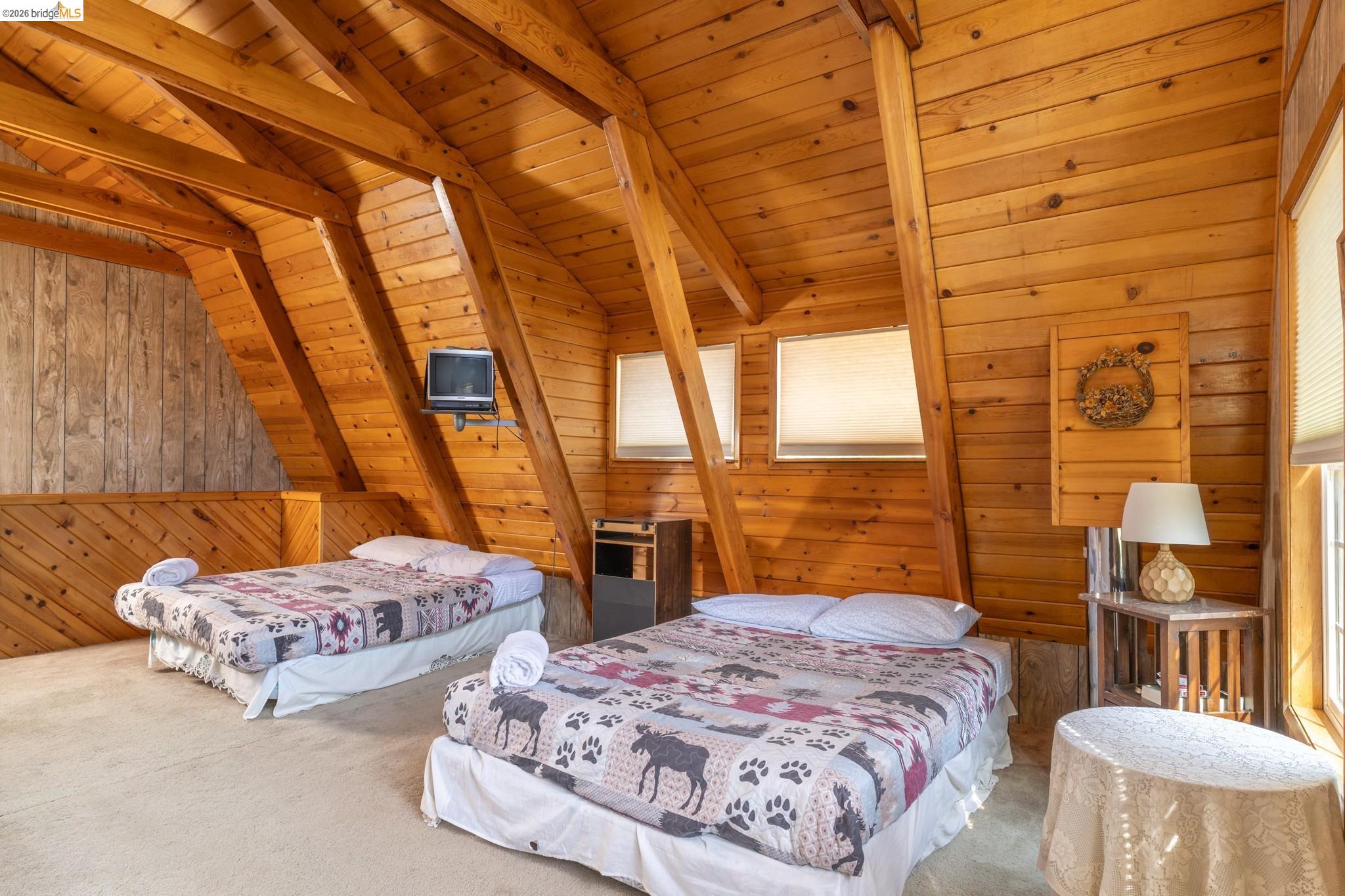 19390 Ferretti Road Groveland, CA 95321 - Photo 25 of 38 Wood paneling and exposed wood beams throughout, with multiple windows providing natural light