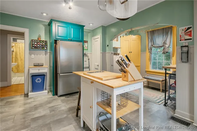 a kitchen that has a table chairs and a refrigerator