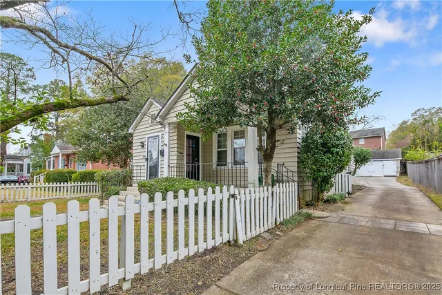 a front view of white house with a small yard