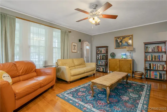 a living room with furniture a rug and a bookshelf
