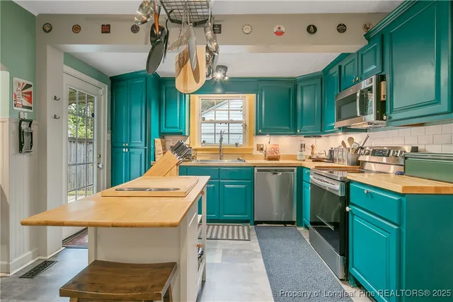 a kitchen that has a sink a table and chairs in it
