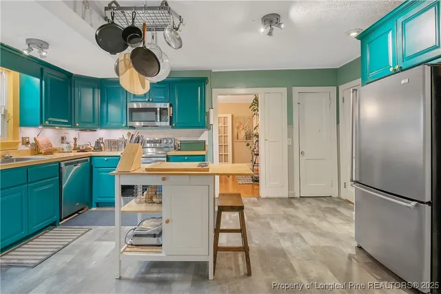 a kitchen with a refrigerator and countertop cabinets