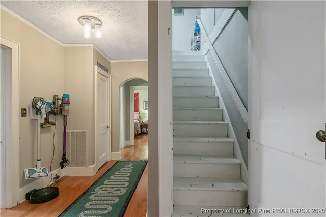 a view of a hallway with wooden floor and staircase