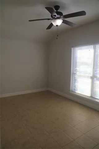 an empty room with a window and a fan