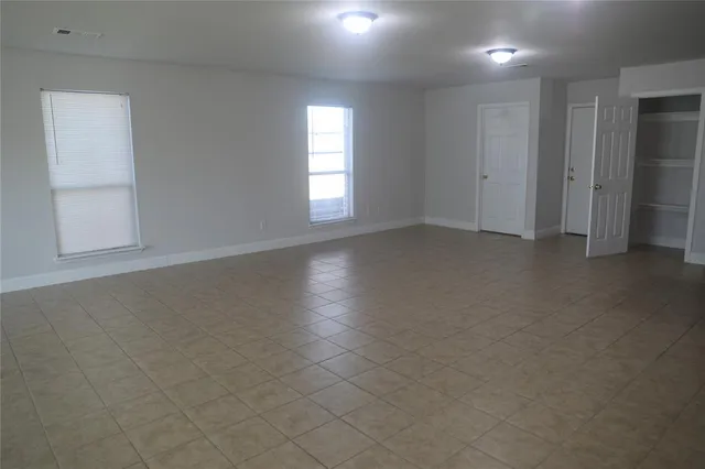 an empty room with windows and closet