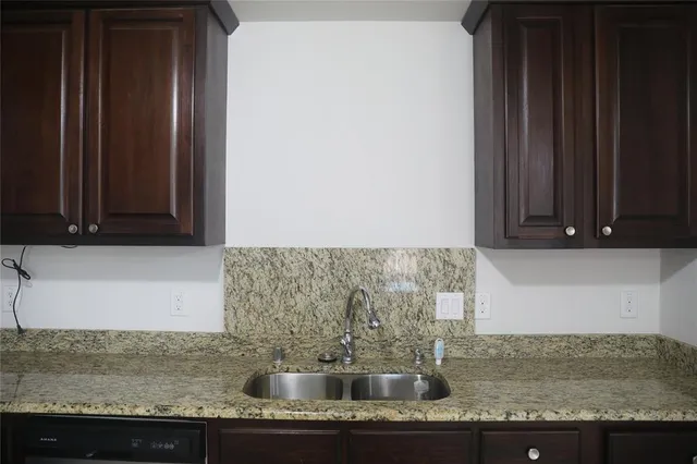 a kitchen with granite countertop a sink and a stove