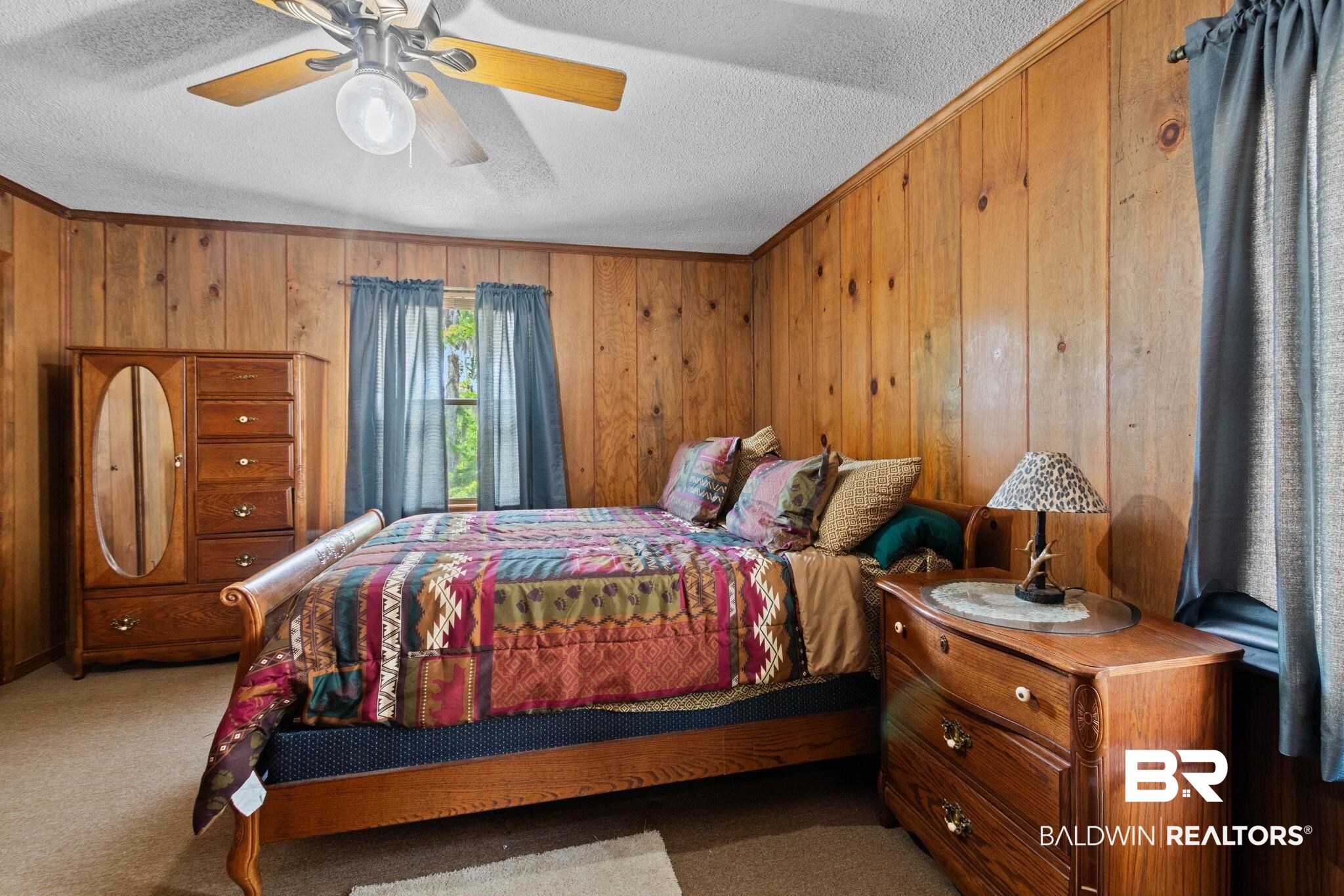 8153 Bryant's Lndg Road Stockton, AL 36579 - Photo 35 of 87 Room featuring wood paneling, a textured ceiling, a window with curtains, and a ceiling fan with light fixture