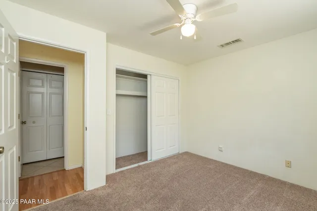 a view of an empty room with a ceiling fan