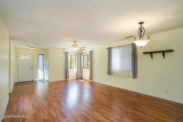 a view of a room with wooden floor chandelier and a window