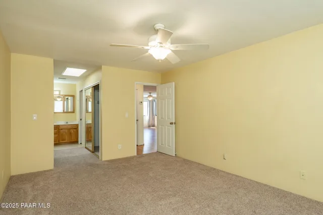 a view of a big room with windows and chandelier fan
