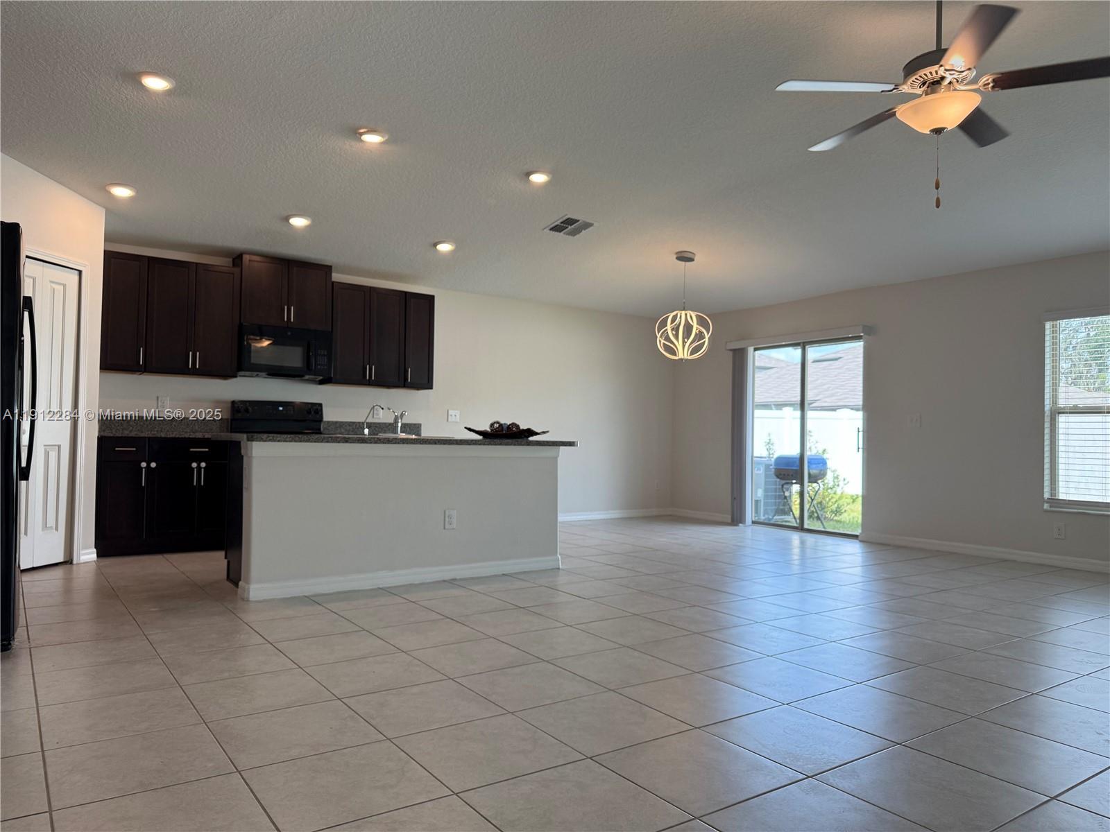 39889 Harmon Grove Court Zephyrhills, FL 33540 - Photo 12 of 55 a large kitchen with stainless steel appliances granite countertop a stove top oven a sink dishwasher and a refrigerator