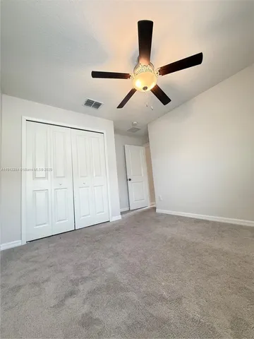 an empty room with a window and a ceiling fan