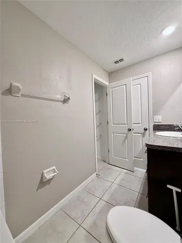 a bathroom with a granite countertop sink a toilet and a mirror