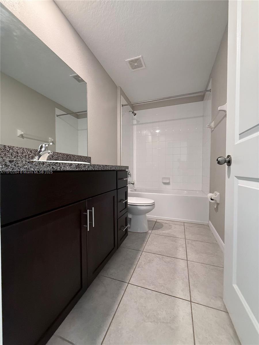 39889 Harmon Grove Court Zephyrhills, FL 33540 - Photo 23 of 55 a bathroom with a granite countertop sink a toilet and a mirror