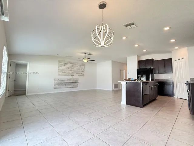 a view of kitchen with stainless steel appliances granite countertop a sink and cabinets