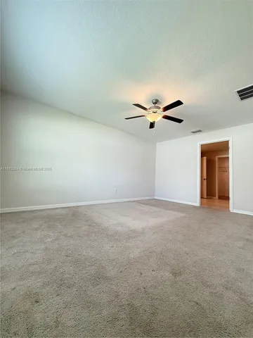 an empty room with windows and ceiling fan view