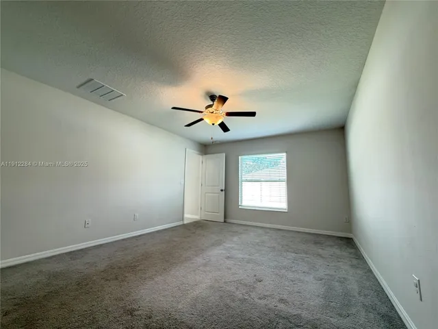 an empty room with closet and windows