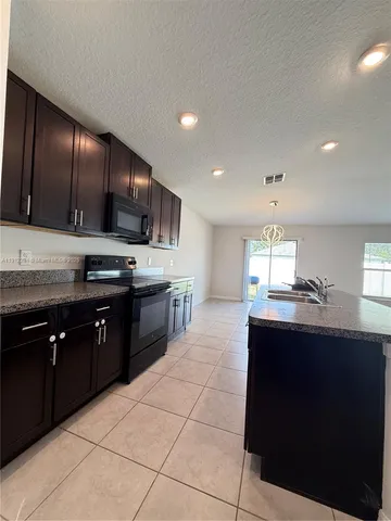 a kitchen with stainless steel appliances granite countertop a sink counter space cabinets and a large window
