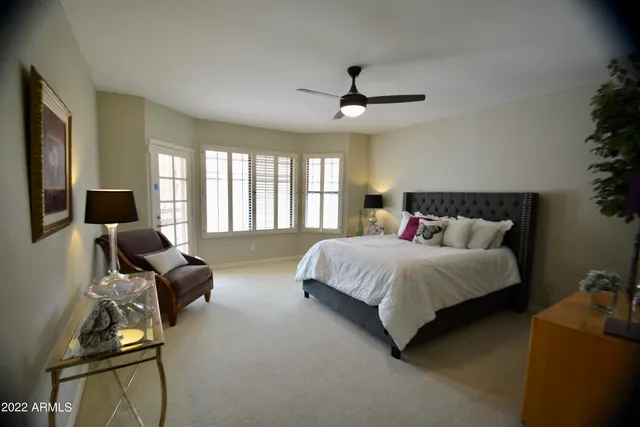 a spacious bedroom with a bed and glass window