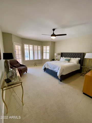 a spacious bedroom with a bed a couch and a window