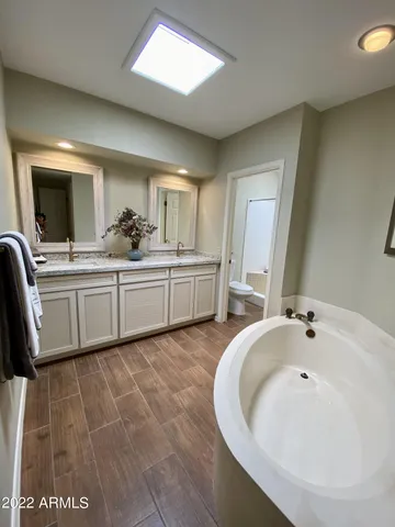 a large white room with a sink and mirror