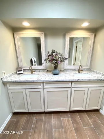 a bathroom with a granite countertop sink and a mirror